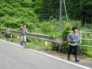 釣竿用の竹を切って運ぶ留学児童の写真