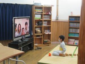 会いたい気持ちをにじませながらオンラインで会話する留学児童の写真