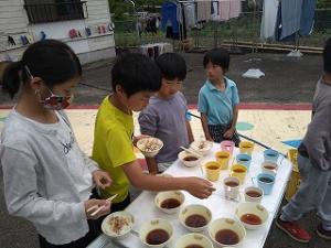 大豆入りのだしを準備する留学児童の写真