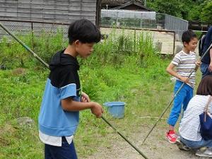真剣に釣りをする留学児童の写真