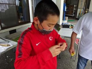 仕掛けの手直しをする留学児童の写真