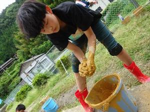 材料の土を練る留学児童の写真