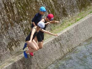 除草後はまた川遊びをする留学児童の写真