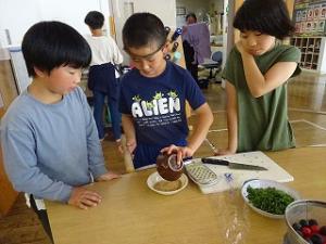 薬味のゴマをする留学児童の写真