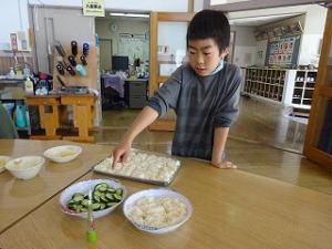 きゅうりの塩もみを準備する留学児童の写真