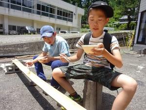 どんと構えてそうめんを待つ留学児童の写真