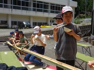 流しそうめんに満足げな留学児童の写真