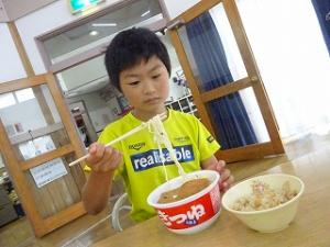 希望のうどんをすする留学児童の写真