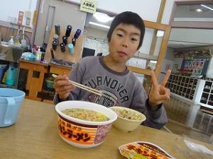 大好物のラーメンに満足げな留学児童の写真