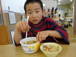 大好きなカレーうどんをすする留学児童の写真