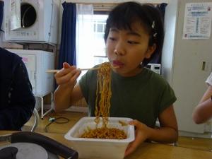 香ばしい焼きそばをすする留学女子の写真