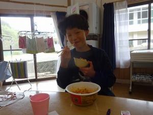 担々麺の予想外の辛さに苦労する留学児童の写真