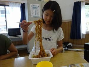 好物のカップ焼きそばにご満悦の留学女子の写真