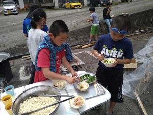 立ち食いスタイルで食べる留学児童の写真