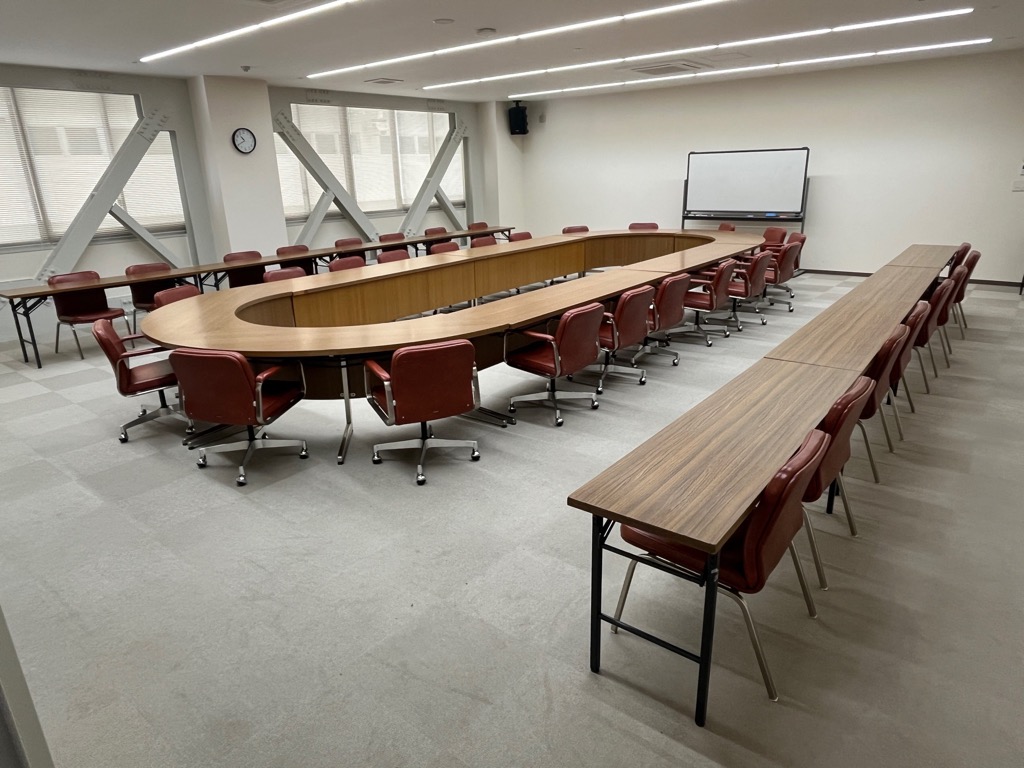 机といすが並んだ会議室の写真