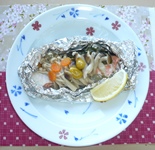 食器に盛りつけられた、切り身魚のホイル焼きの写真