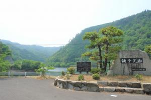 銚子ダムと書かれた石造りの看板が設置された銚子ダム入口の写真