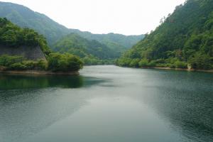 新緑が映える中で通常の水位の銚子ダムの写真