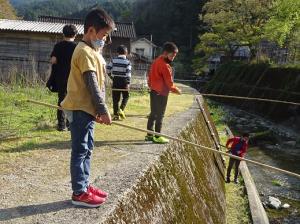 高市川で釣りをする留学児童の写真
