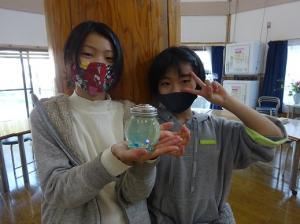 草花で色水を作る留学児童の写真