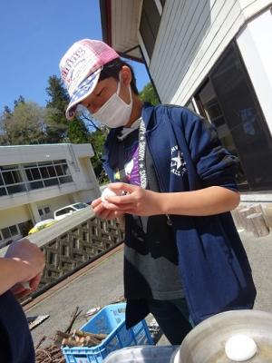 ピーラーでジャガイモの皮をむく留学児童の写真