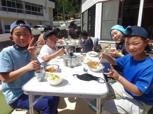 みんなで楽しくカレーライスを食べる留学児童の写真