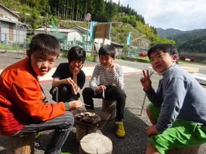 おやつに焼きシイタケを食べる留学児童の写真