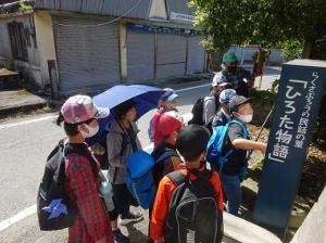 出発してすぐに碑の前で道草する留学児童の写真