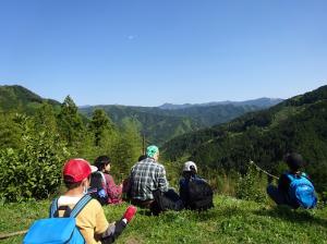 眺めの良いところで休憩する留学児童の写真