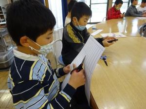 設計図から部品を切り取る留学児童の写真