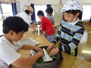 ホットプレートを使い茶葉を乾燥させる留学児童の写真