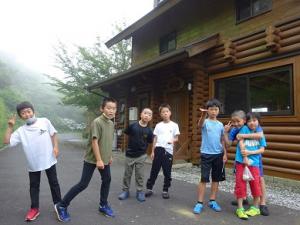コテージ前で記念撮影する留学男子の写真