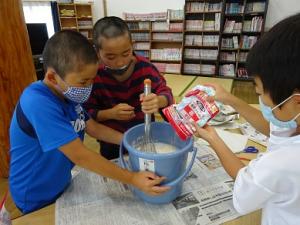 決め手のだしづくりに真剣な留学児童の写真
