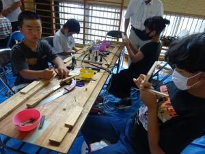 自然の材料を組み合わせる留学児童の写真