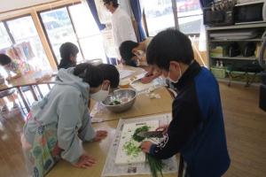 餡の材料を細かく刻む留学児童の写真