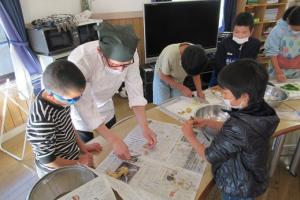 講師から手ほどきを受ける留学児童の写真