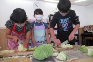 大量のキャベツと格闘する留学児童の写真