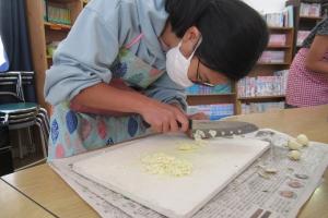 ニンニクをみじん切りにする留学児童の写真