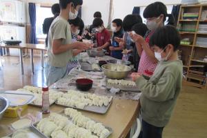 餃子の皮を包む留学児童の写真
