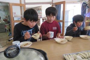黙々と餃子を食べる留学児童の写真