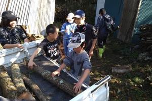 炭窯に原木を下す留学児童の写真