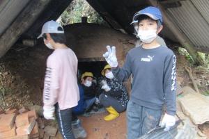 バケツリレーの要領で炭を運ぶ留学児童の写真