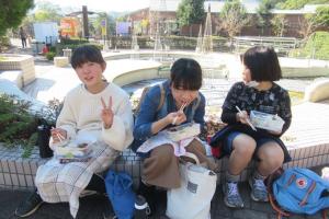仲良し3人組で昼食を食べる留学児童の写真