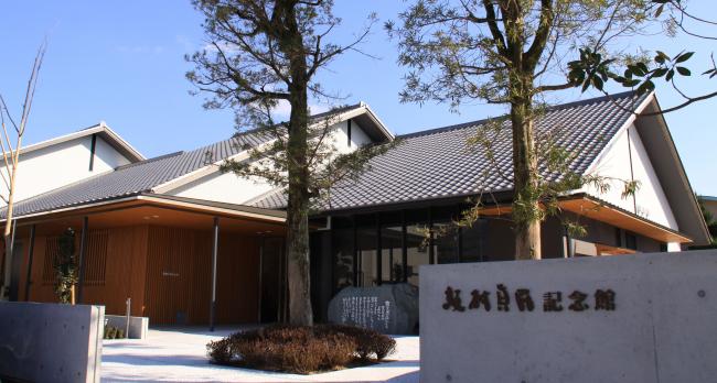 2本の木が正面に並ぶ坂村真民記念館の外観を写した写真