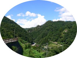 少し雲がかった晴天の青空を背景に、広田地域の山々の豊かな自然を写した写真