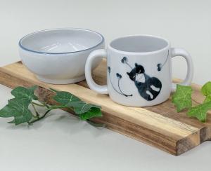 ハチワレネコが描かれた両手持ちマグカップと小鉢が並んでいる写真