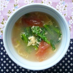 食器に盛りつけられた、菜の花とトマトのスープの写真